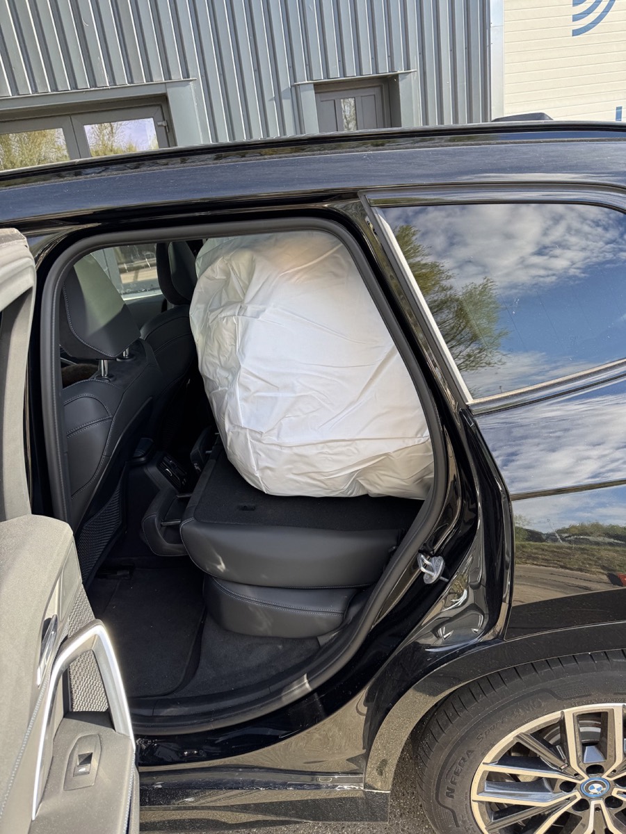 De opgevouwen opblaasbare feesttent van Airclub op de achterbank van een auto, klaar om bezorgd te worden
